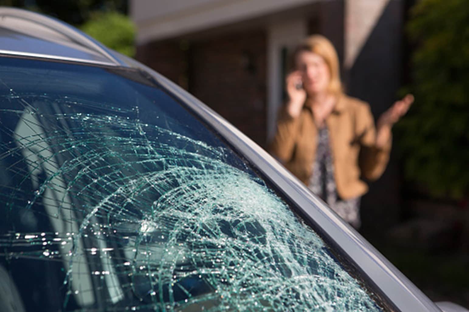 A car's windshield is broken and a women is on a call in Surrey, BC