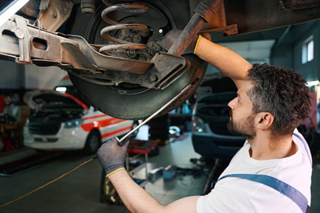 A man is working on car suspension in Surrey, BC