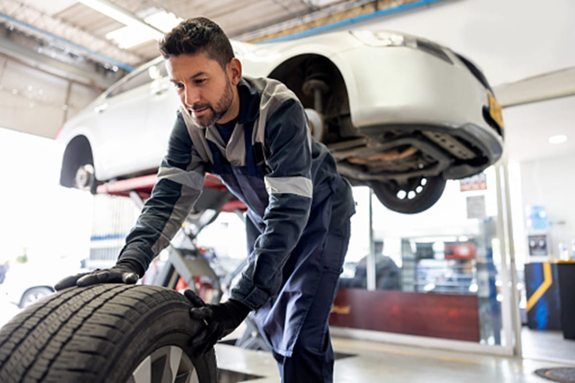 A man is working with tires in a car workshop in Surrey, BC