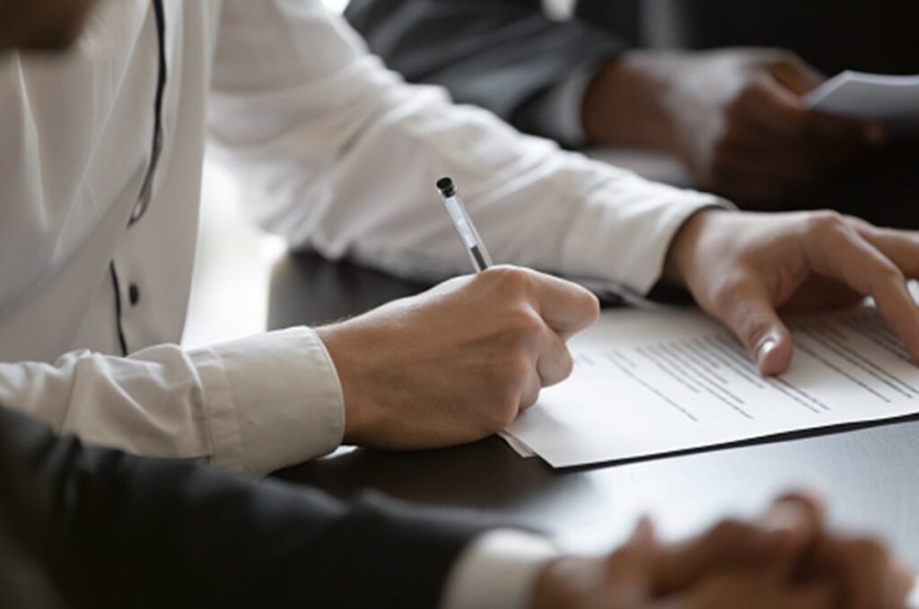 A man is signing documents in Surrey, BC