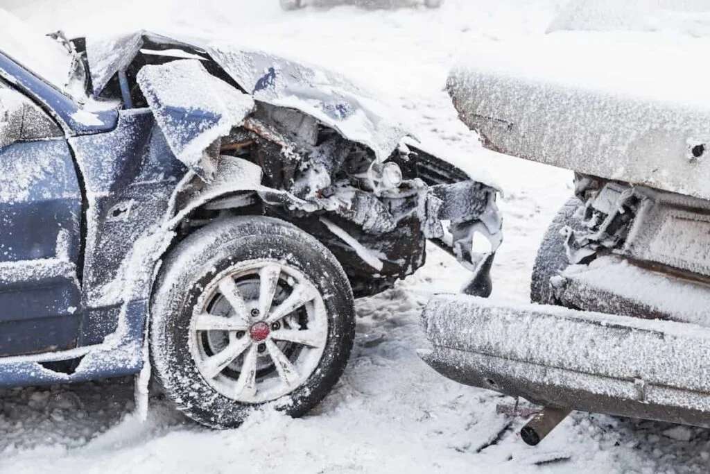 Snow-covered cars with severe front-end damage after a winter collision in Surrey, BC